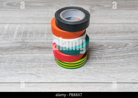 Certains rouleaux de ruban isolant de différentes couleurs sur une table en bois Banque D'Images