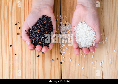 Riz Noir et blanc dans les mains. Studio Photo Banque D'Images