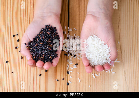 Riz Noir et blanc dans les mains. Studio Photo Banque D'Images