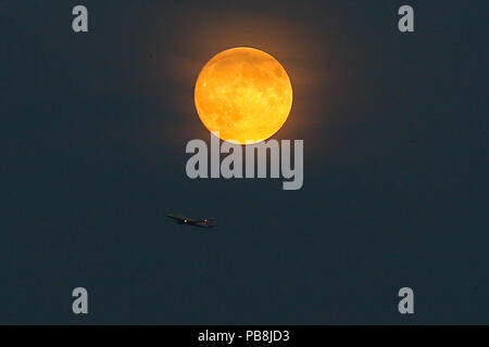 Le nord de Londres. Londres. UK 26 Juillet 2018 - Un avion de British Airways au-dessous de la Lune de sang dans le nord de Londres, comme la plus longue éclipse lunaire du siècle, fixée pour le vendredi 27 juillet 2018, a déjà commencé en tournant le corps céleste une profonde couleur écarlate. La Lune de sang sera le premier britannique de chance de voir un grand eclipse en 2018, et selon la NASA's Moon experts au Centre spatial Goddard, l'éclipse durera environ une heure et 43 minutes. Credit : Dinendra Haria/Alamy Live News Banque D'Images