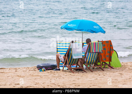 Bournemouth, Dorset, UK. 27 juillet 2018. Météo France : la station de tête Sunseekers à bronzer sur les plages de Bournemouth sur un jour chaud et humide avec quelques nuages. Vous relaxant dans des chaises longues sur la plage. Credit : Carolyn Jenkins/Alamy Live News Banque D'Images