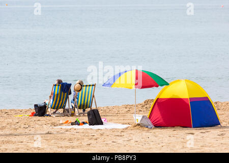 Bournemouth, Dorset, UK. 27 juillet 2018. Météo France : la station de tête Sunseekers à bronzer sur les plages de Bournemouth sur un jour chaud et humide avec quelques nuages. Chaises longues, parasol et tente sur la plage. Credit : Carolyn Jenkins/Alamy Live News Banque D'Images