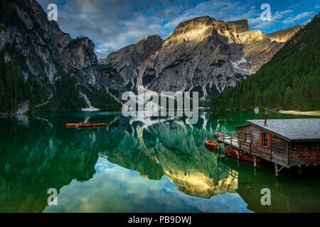 Lac de montagne verte avec des bateaux et d'un hangar à bateaux, Seekogel point culminant en l'arrière, de l'eau reflet, lac Prags, Dolomites, Italie Banque D'Images