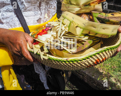 Asian woman holding un panier rempli d'offrandes dans ses mains, le Temple Besakih, Bali, Indonésie Banque D'Images