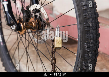 Vieux vélo sécurité forte serrure à clé à chaîne de roue avant Banque D'Images