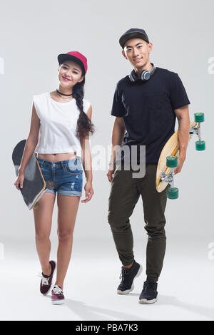 Portrait of young couple holding skateboard chinois Banque D'Images