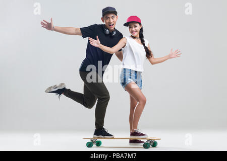 Cheerful young couple skateboarding Banque D'Images