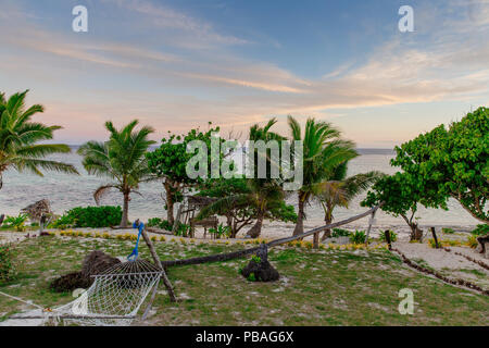 Lazy hammock couchers de soleil sur la côte de corail des Îles Fidji Banque D'Images