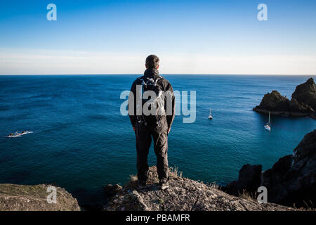 Une vue arrière d'un randonneur ou backpacker mâle debout sur une haute falaise et admirer une source sur la mer Banque D'Images