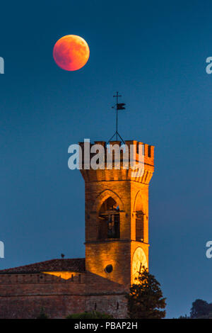 Eclipse de Lune rouge sur la tour de l'horloge en Italie Banque D'Images