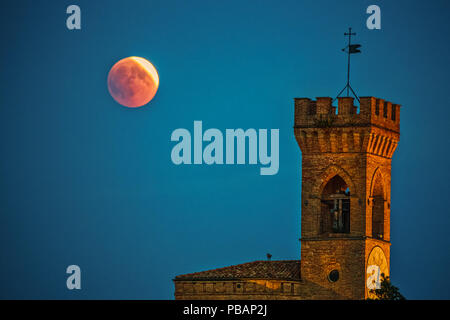 Eclipse de Lune rouge sur la tour de l'horloge en Italie Banque D'Images