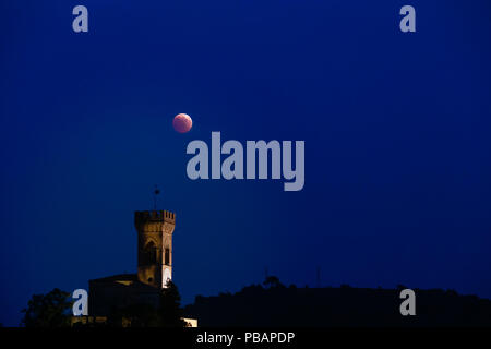 Eclipse de Lune rouge sur la tour de l'horloge en Italie Banque D'Images