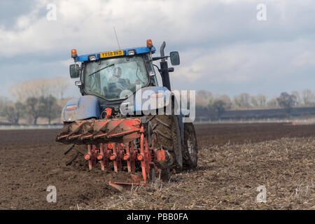 Labourer un champ avec un New Holland T7030 et d'un sillon de charrue Kuhn 5 réversible, la position de l'établissement. North Yorkshire, UK. Banque D'Images