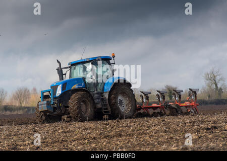 Labourer un champ avec un New Holland T7030 et d'un sillon de charrue réversible 5 Kuhn, North Yorkshire, UK. Banque D'Images