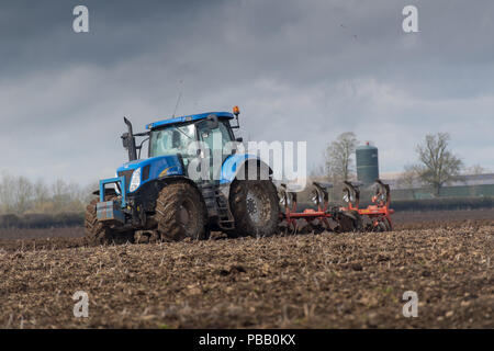 Labourer un champ avec un New Holland T7030 et d'un sillon de charrue réversible 5 Kuhn, North Yorkshire, UK. Banque D'Images