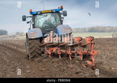 Labourer un champ avec un New Holland T7030 et d'un sillon de charrue Kuhn 5 réversible, la position de l'établissement. North Yorkshire, UK. Banque D'Images