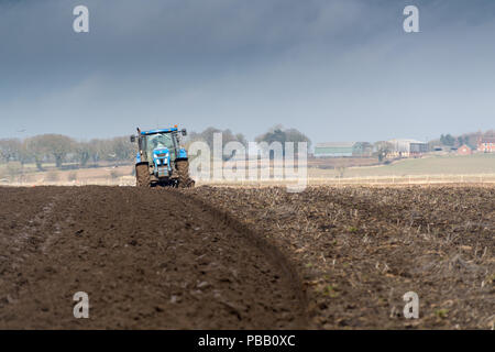 Labourer un champ avec un New Holland T7030 et d'un sillon de charrue réversible 5 Kuhn, North Yorkshire, UK. Banque D'Images