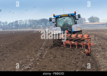 Labourer un champ avec un New Holland T7030 et d'un sillon de charrue Kuhn 5 réversible, la position de l'établissement. North Yorkshire, UK. Banque D'Images