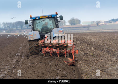 Labourer un champ avec un New Holland T7030 et d'un sillon de charrue Kuhn 5 réversible, la position de l'établissement. North Yorkshire, UK. Banque D'Images