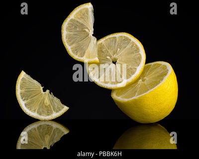 Les tranches de citron, des morceaux sur un fond noir. Photo inhabituelle. Semblent défier la gravité Banque D'Images