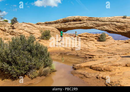 Les touristes à un petit arc dans Arches National Park dans l'Utah Banque D'Images