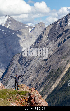 Un jeune randonneur debout à la lisière de Parker Ridge crest sur la Promenade des glaciers dans le Parc National Jasper avec les Rocheuses en arrière-plan. Banque D'Images