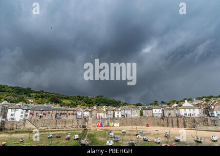 Mousehole, Cornwall, UK. 28 juillet 2018. Météo britannique. Un ciel noir et les précipitations sur l'extrême sud à l'ouest de Cornwall aujourd'hui, alors que la vague se brise. Crédit : Simon Maycock/Alamy Live News Banque D'Images