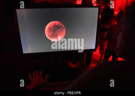 Munich, Allemagne. 27 juillet, 2018. Dans la plus longue éclipse lunaire totale du 21e siècle, la lune peut être vu sur le moniteur d'un télescope de l'Observatoire du peuple. Dans la plus longue éclipse lunaire du 21e siècle, la lune plonge dans l'ombre de la Terre. Crédit : Felix Hörhager/dpa/Alamy Live News Crédit : afp photo alliance/Alamy Live News Banque D'Images