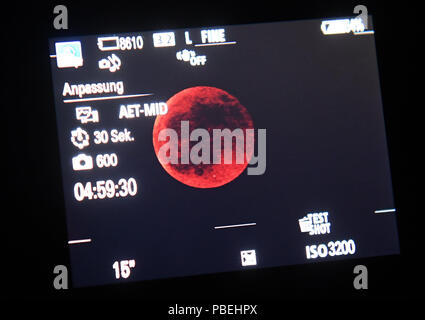 Munich, Allemagne. 27 juillet, 2018. Dans la plus longue éclipse lunaire totale du 21e siècle, la lune peut être vu sur un petit moniteur près de l'oculaire d'un télescope de l'observatoire. Dans la plus longue éclipse lunaire du 21e siècle, la lune plonge dans l'ombre de la Terre. Crédit : Felix Hörhager/dpa/Alamy Live News Crédit : afp photo alliance/Alamy Live News Banque D'Images