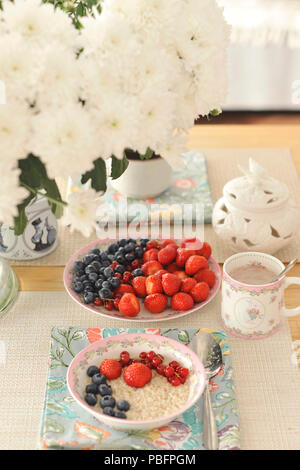 Petits fruits pour le petit déjeuner. une table décorée avec des fleurs. Banque D'Images