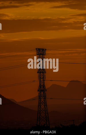 Reflet couleur orange et la couleur d'or par le soleil se cacher derrière la colline d'une colline. Tower et les veaux d'une haute tension ou courant électrique de la CFE. Coucher du soleil à l'ouest d'Hermosillo, Sonora être la capitale de l'un des meilleurs dans le pays. Des températures élevées. Crépuscule centigrades. Altas temperaturas. Centigrados. Crepusculo. (Photo : Luis Gutiérrez / NortePhoto.com) Banque D'Images