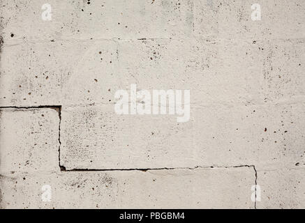 La texture d'un vieux mur, de grandes briques peint en blanc avec une fissure sur un côté. Banque D'Images