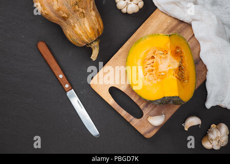 Couper des morceaux de potiron avec graines dans plaque de bois sur la planche de bois.Harvest,Fresh Vegetable, ingrédient de base de l'alimentation.White.Vue d'en haut Banque D'Images