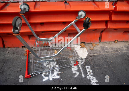 Un panier est laissé à l'envers à pied dans la ville près de site de construction. Banque D'Images