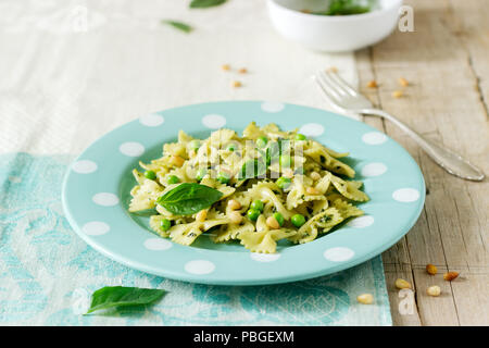 Les Pâtes au pesto, les pois verts et basilic sur une table en bois. De style rustique, selective focus. Banque D'Images