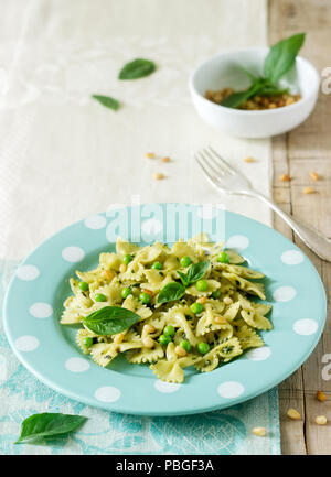 Les Pâtes au pesto, les pois verts et basilic sur une table en bois. De style rustique, selective focus. Banque D'Images