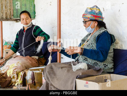 Les femmes tissant des fils de soie dans l'établissement des réfugiés tibétains dans la région de Pokhara, Népal Banque D'Images