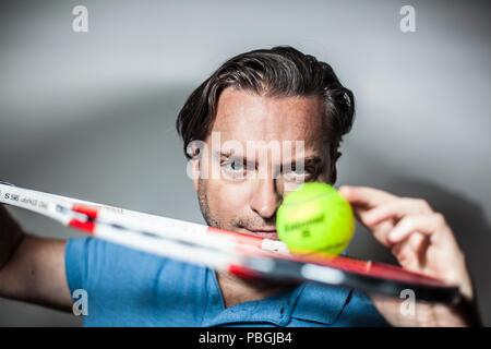 Portrait d'un bel homme avec une raquette de tennis Banque D'Images
