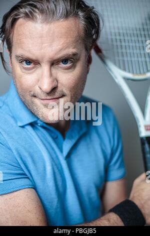 Portrait d'un bel homme avec une raquette de tennis Banque D'Images