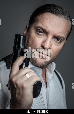 Portrait of a handsome man holding a gun Banque D'Images