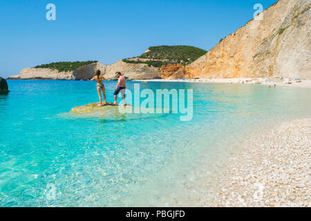 Plage de Porto Katsiki à Lefkada île Ionienne, en Grèce. Vue sur la mer turquoise, eaux de l'océan. Un couple est debout sur un rocher dans la mer. Banque D'Images