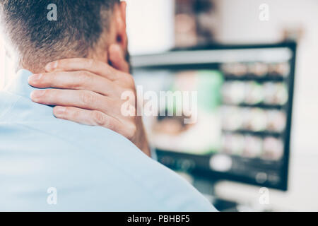 Employée de bureau avec le cou et la douleur dorsale de siéger au bureau toute la journée Banque D'Images
