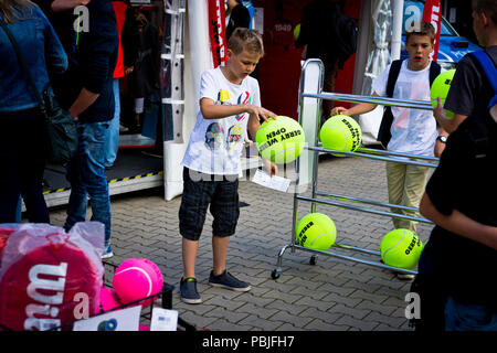 Un jeune garçon rebondit une immense balle de tennis à un blocage de marchandises au Gerry Weber Stadion à Halle (Westfalen), Allemagne. Banque D'Images