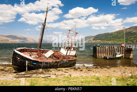 Un bateau de pêche échoués sur les listes sur les rives du Loch Linnhe au village de Ardgour dans l'ouest des Highlands d'Écosse. Banque D'Images