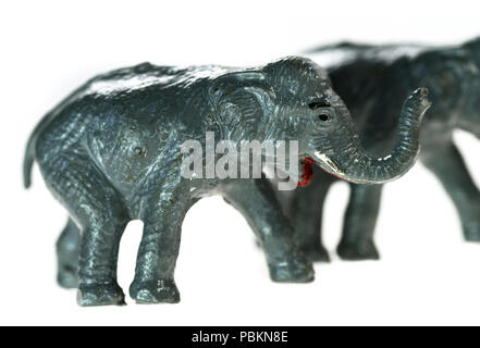 Les éléphants d'un jouet vintage Noah's Ark jouer ensemble, photographié sur un fond blanc. Banque D'Images