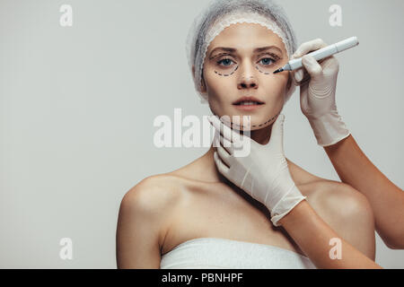 Offre d'encombrement des lignes en pointillé sur le visage féminin avant la chirurgie plastique pour le rajeunissement du visage. Les lignes en pointillé sur la Cosmetologist visage féminin b Banque D'Images