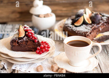 Gâteau au chocolat aux fruits rouges et de café, d'une décoration de groseilles rouges et des figues. Fruits d'automne et des viennoiseries pour le petit déjeuner Banque D'Images