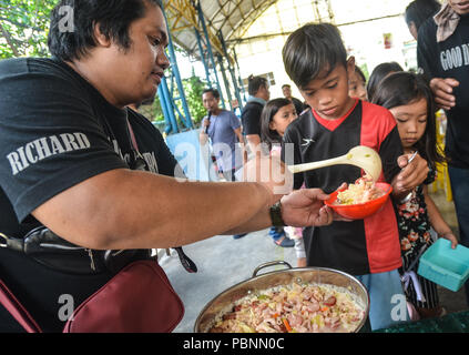 Quezon City, Philippines. 28 juillet, 2018. Les enfants d'attente au cours de l'événement de service communautaire du programme d'alimentation. Crédit : Robert Oswald Alfiler/Pacific Press/Alamy Live News Banque D'Images