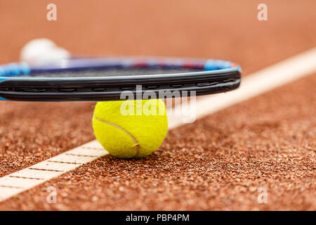 Raquette de tennis et la balle placée sur le sol de la cour Banque D'Images
