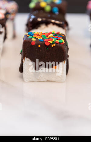 Confettis et Bonbons au chocolat en face de cube de guimauve Banque D'Images